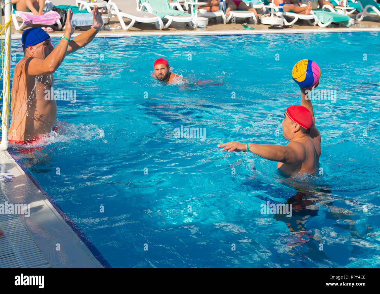 Alanya, Turkey - October 05, 2018. A group of people plays water polo in the blue clear water of the Kirman Sidera Luxury hotel pool. Fitness concept, Stock Photo