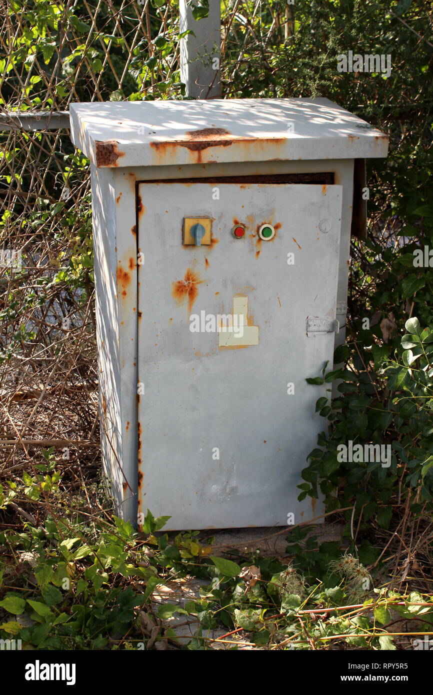 Partially rusted grey electrical high voltage outdoor box with safety