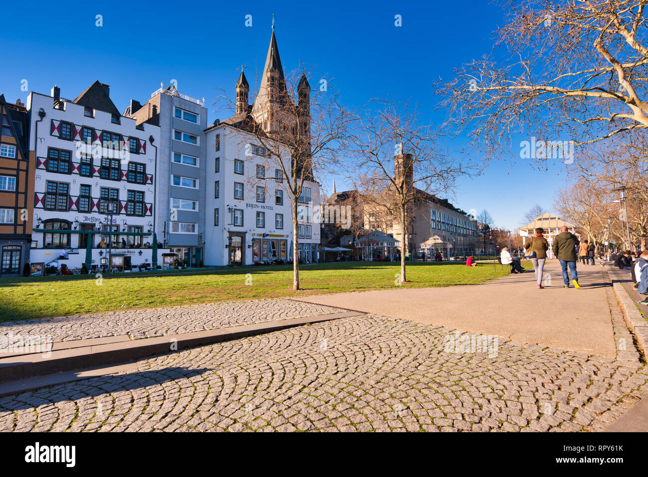 Cologne, GERMANY - February 15, 2019: Unidentified pedestrants enjoy the warm winter sun at the historic Rhein promenade of Cologne. Stock Photo
