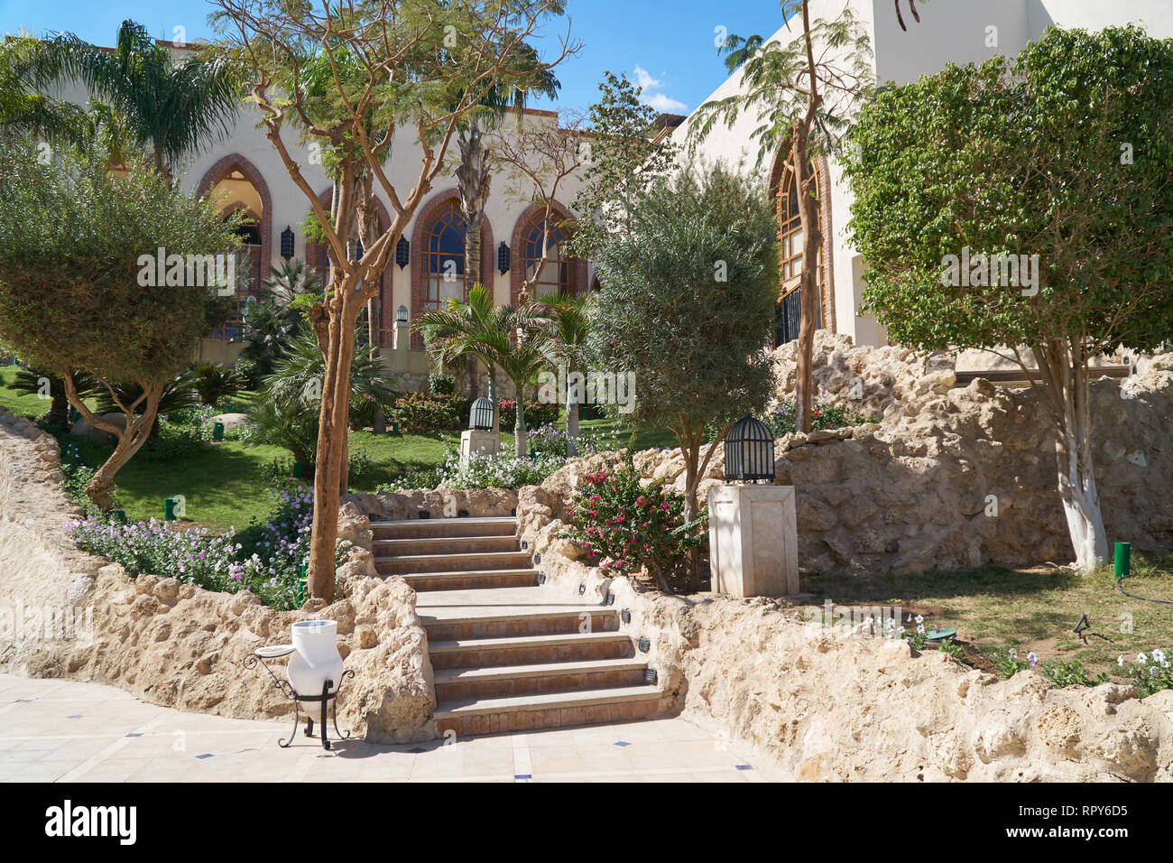 Sharm El Sheikh, Egypt - February 9, 2019: Five-star The Grand Hotel with palms Footpath between green grass in territory in summer Stock Photo