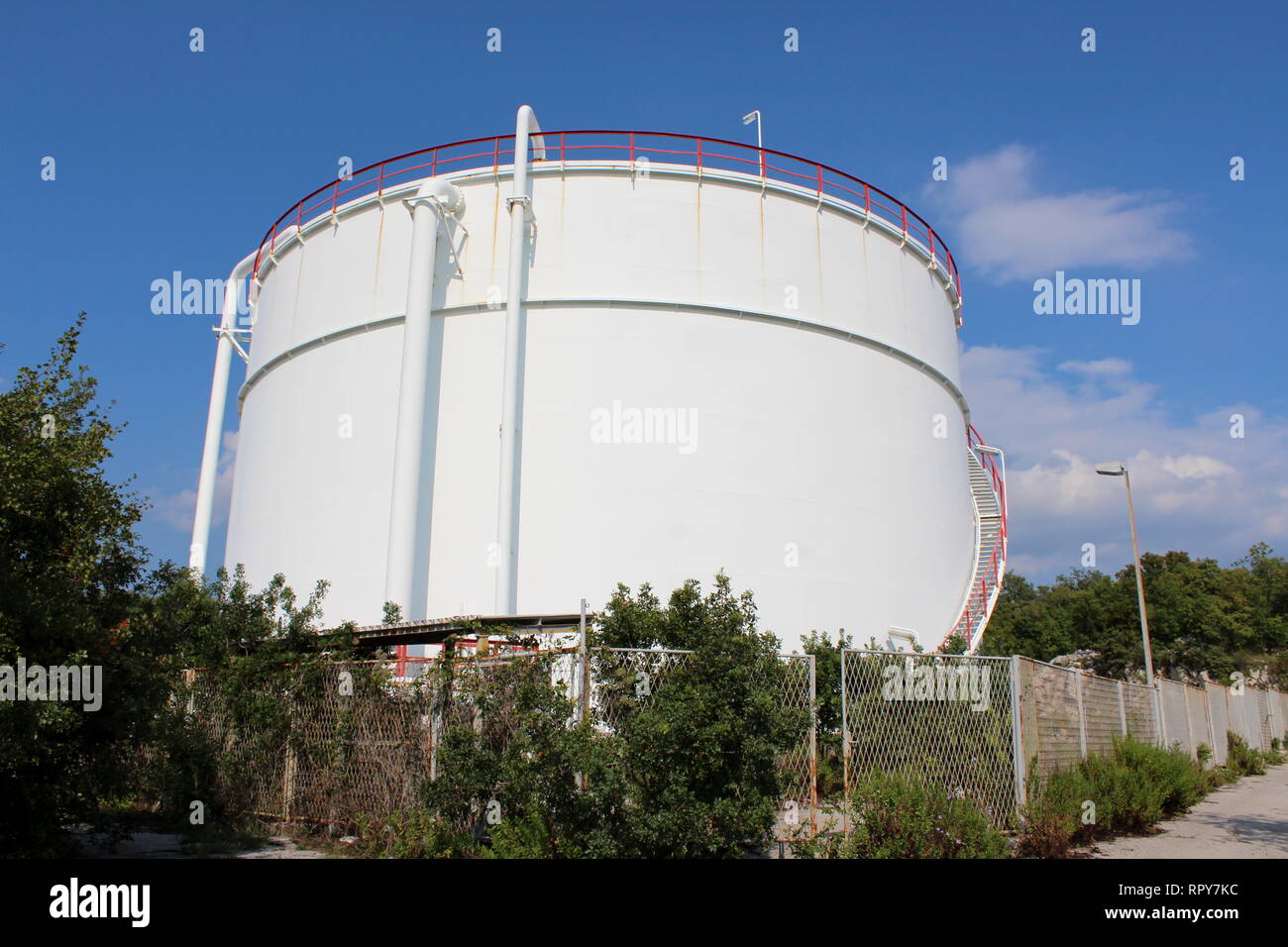 White metal round storage silo with steps on one side and security