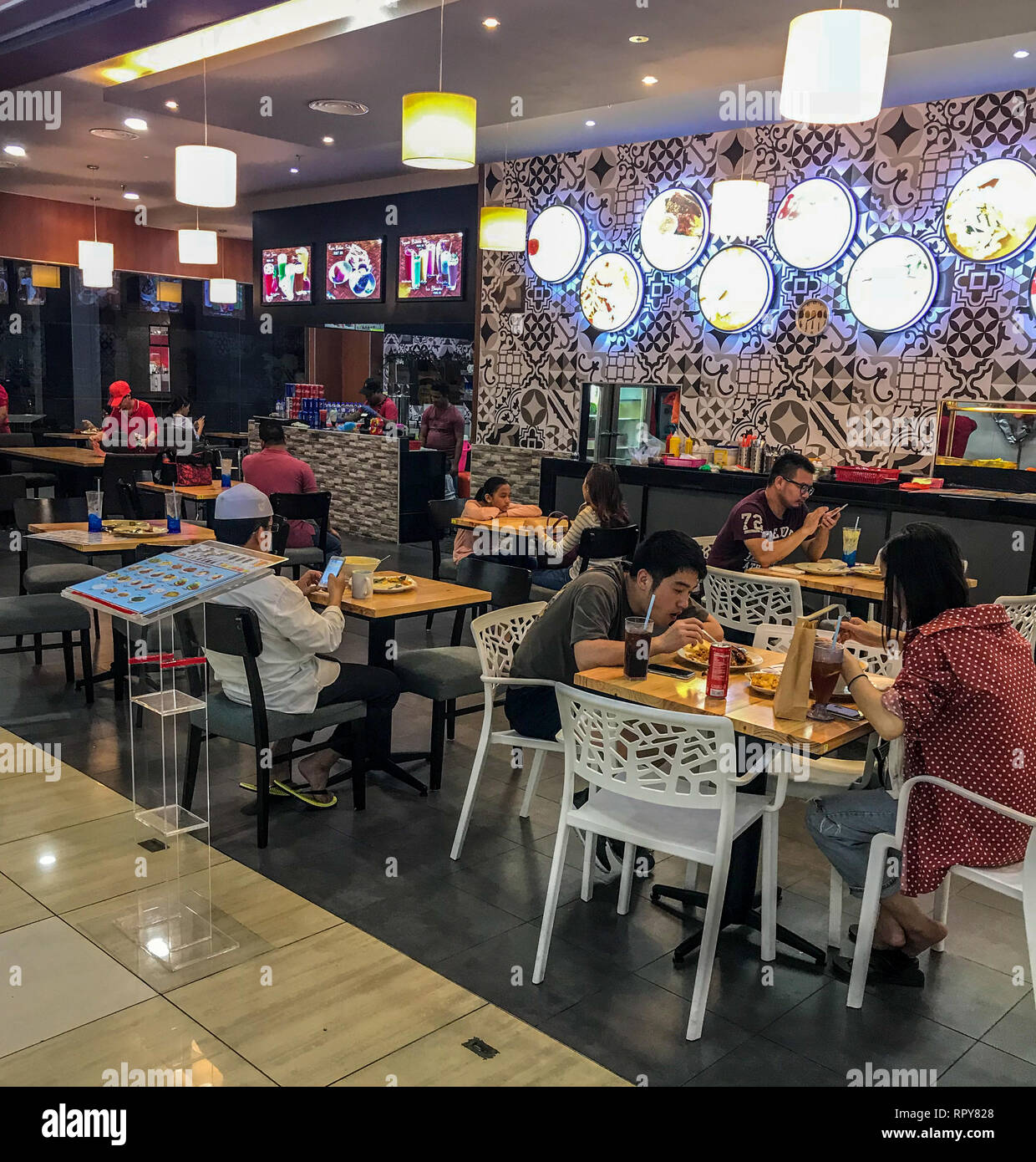Malaysians Eating in a Small Restaurant in a Shopping Mall, Melaka, Malaysia. Stock Photo