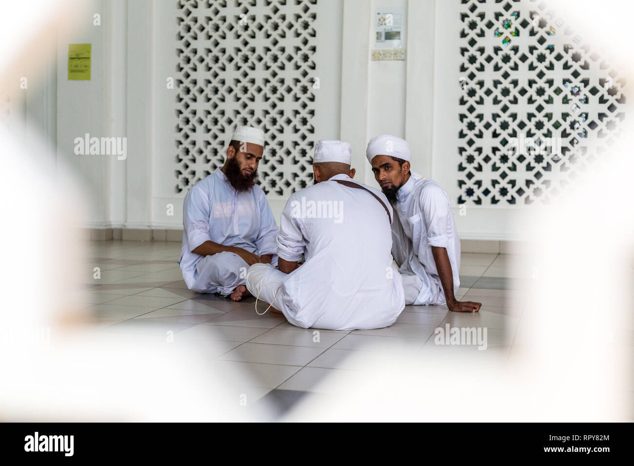 Bangladeshi Muslim Men Talking at the Melaka Straits Mosque, Masjid Selat, the Floating Mosque, Melaka, Malaysia. Stock Photo