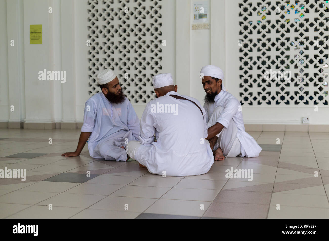 Bangladeshi Muslim Men Talking at the Melaka Straits Mosque, Masjid Selat, the Floating Mosque, Melaka, Malaysia. Stock Photo
