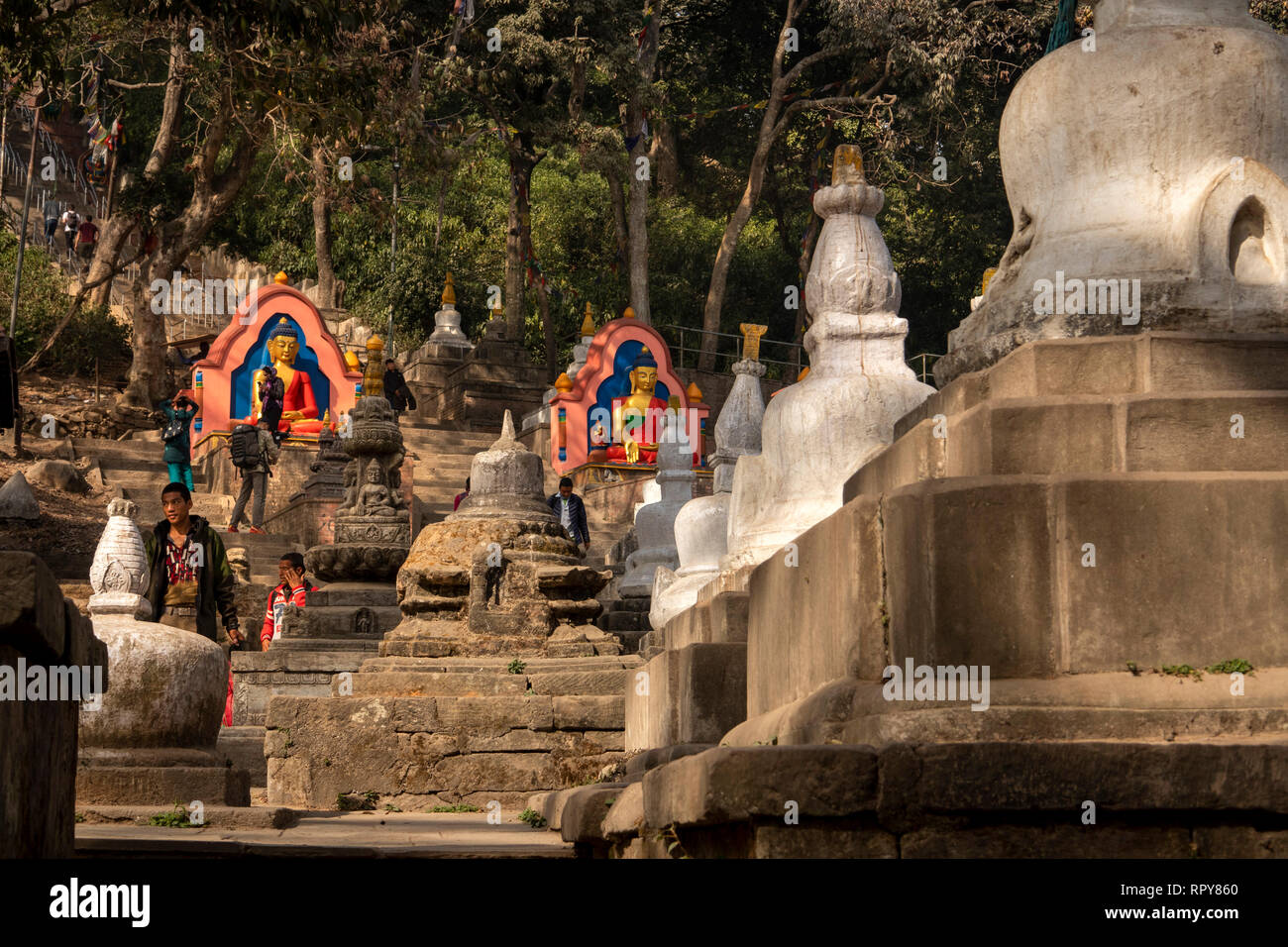 Nepal, Kathmandu, Swayambhunath Temple, Buddha figures and stelae at base of steps to temple Stock Photo