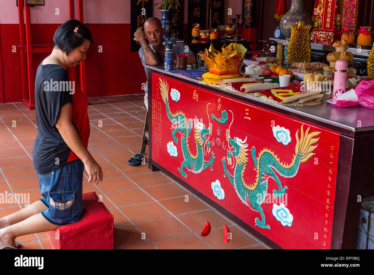 Worshiper Using Jiaobei Blocks to Seek Direction from the Gods, San Duo Chinese Temple, Melaka, Malaysia. Stock Photo