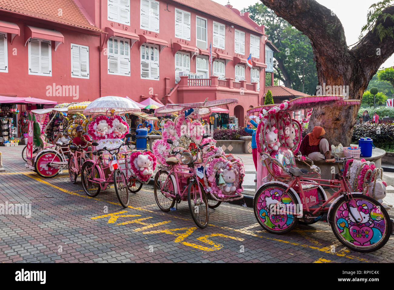 Stadthuys in background, Trishaws in foreground Await Tourists. Melaka, Malaysia. Stock Photo