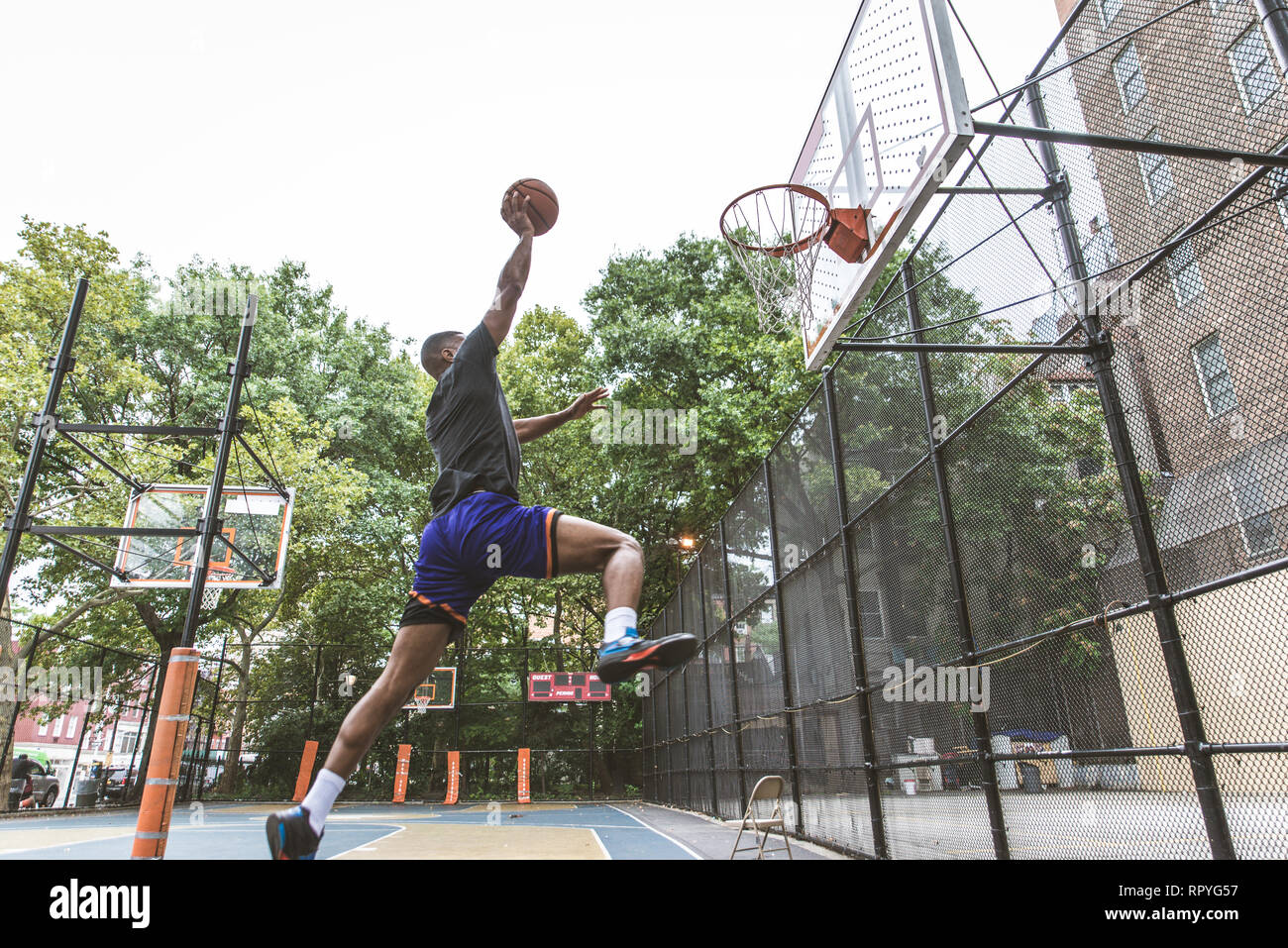 Afroamerican basketball player training on a court in New York Sportive man playing basket