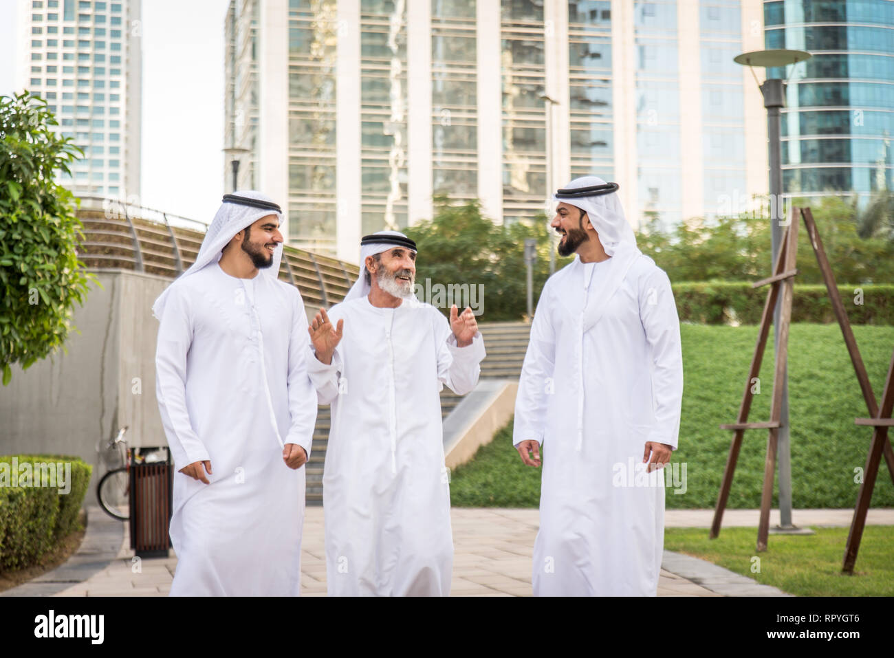 Group of arabian businessmen with kandura meeting outdoors in UAE - Middle-eastern men in Dubai Stock Photo