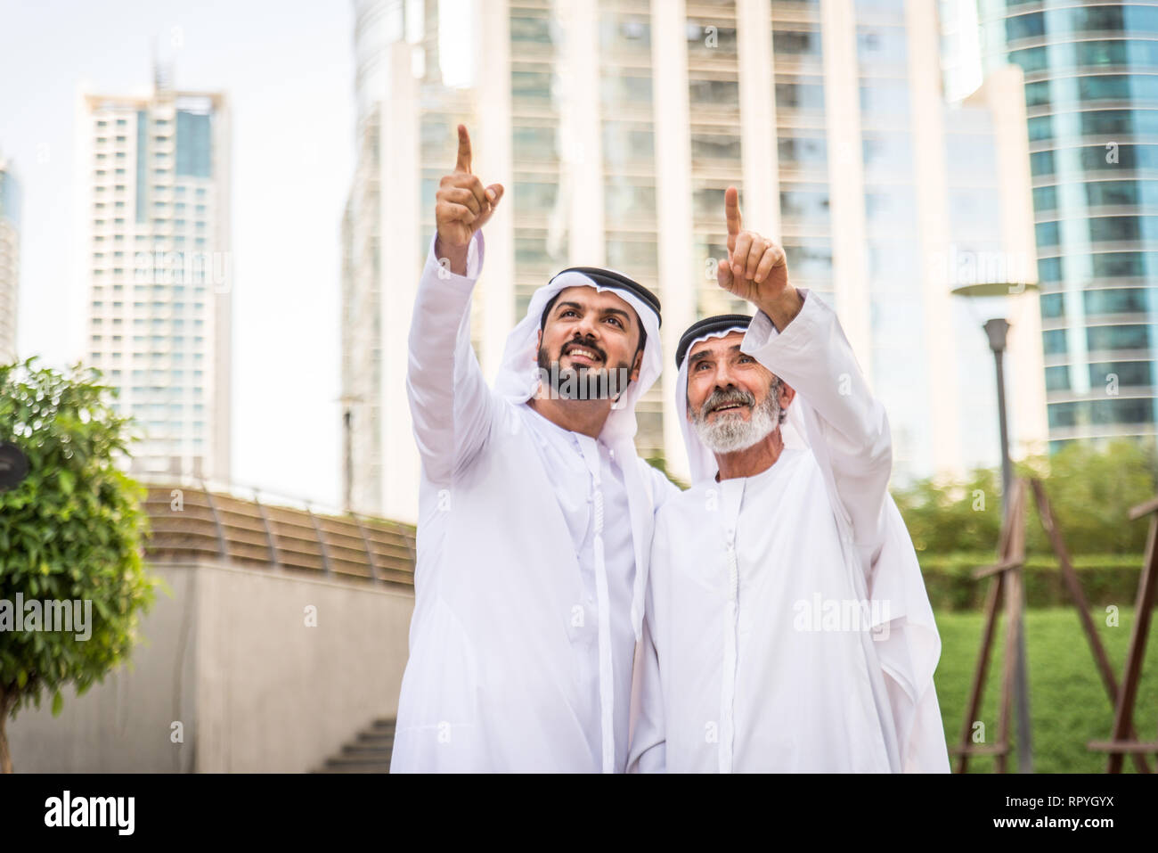 Group of arabian businessmen with kandura meeting outdoors in UAE - Middle-eastern men in Dubai Stock Photo