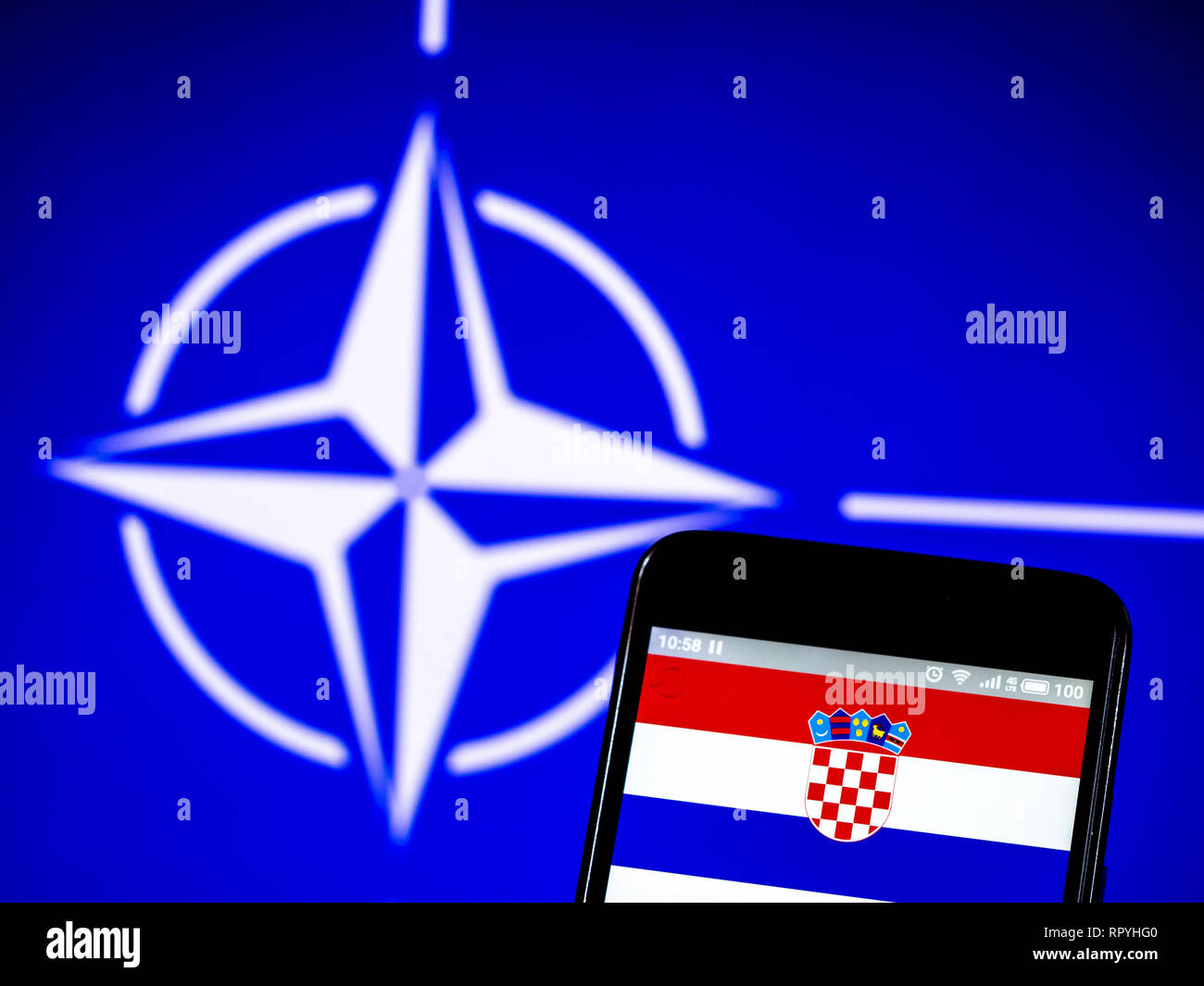 Ukraine. 23rd Feb, 2019. Croatia flag seen displayed on a smartphone with a NATO flag in the background. Credit: Igor Golovniov/SOPA Images/ZUMA Wire/Alamy Live News Stock Photo