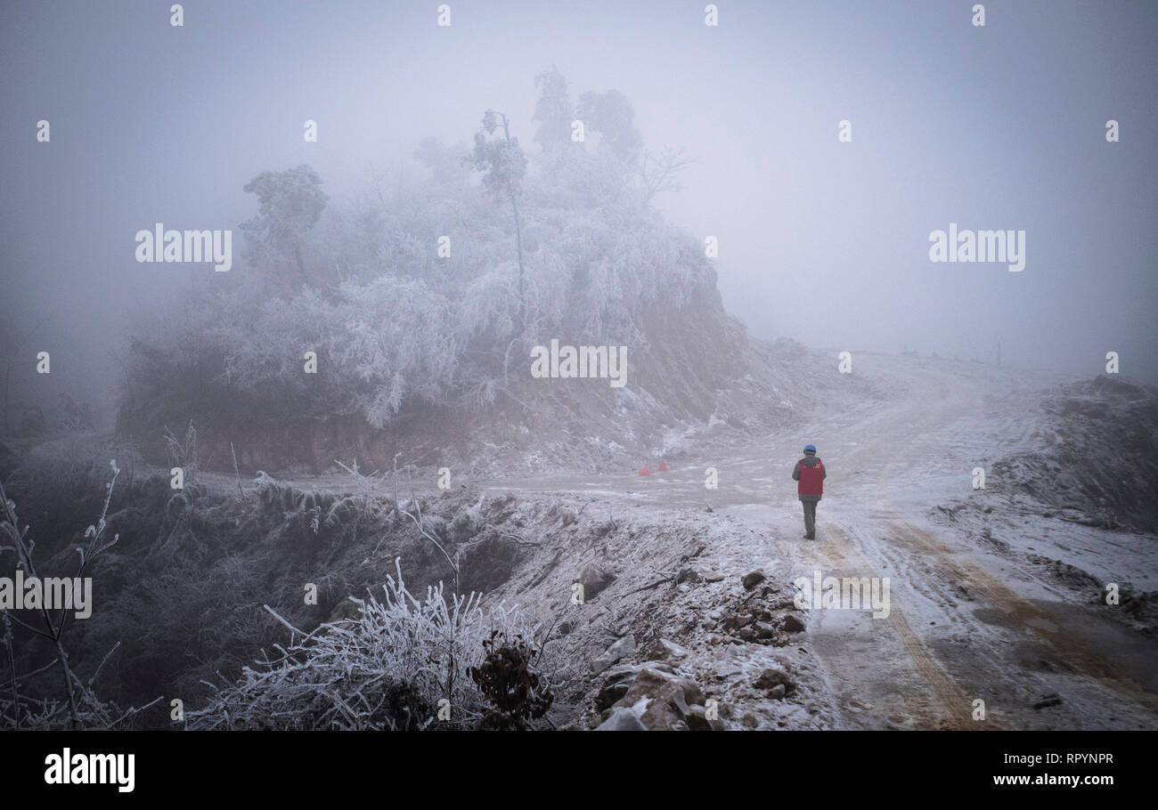 (190223) -- WUHAN, Feb. 23, 2019 (Xinhua) -- Photo taken on Feb. 12, 2019 shows an electrician participating in the rush repairs in the mountain area of Wuhan, capital of central China's Hubei Province. A team of electricians was dispatched to repair a high voltage wire that was broken due to thick layer of ice accumulation. After one day's work on the over 40-meter-high power transmission tower in bad weather condition, the team succeeded in fixing the failed power system that lowered the trains' speed causing delay during the post-holiday travel peak. This year's Spring Festival travel rush  Stock Photo