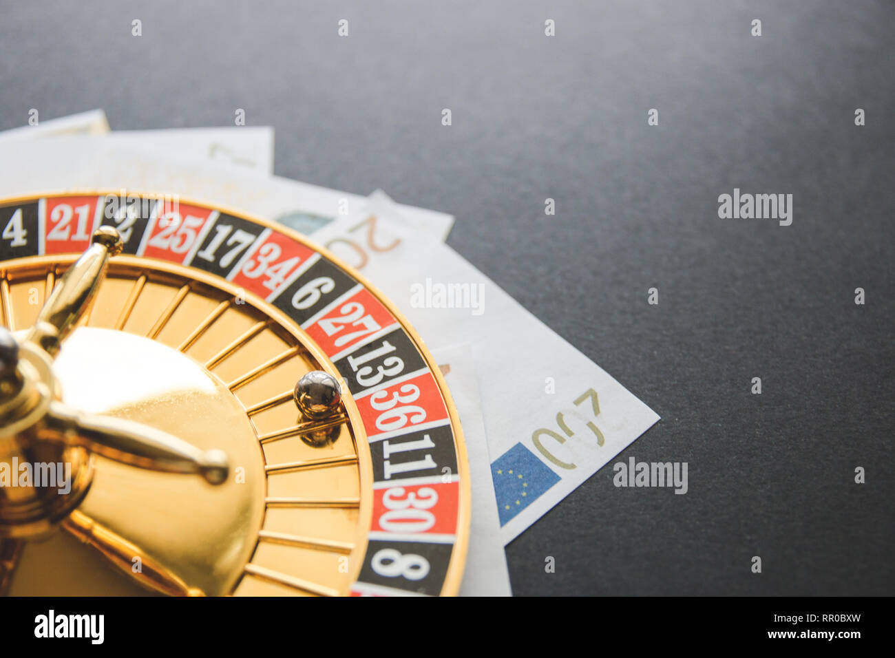 Gold casino theme. Image of casino roulette, poker games, money on the  table, all on a dark bokeh background. Place for printing and logo Stock  Photo - Alamy
