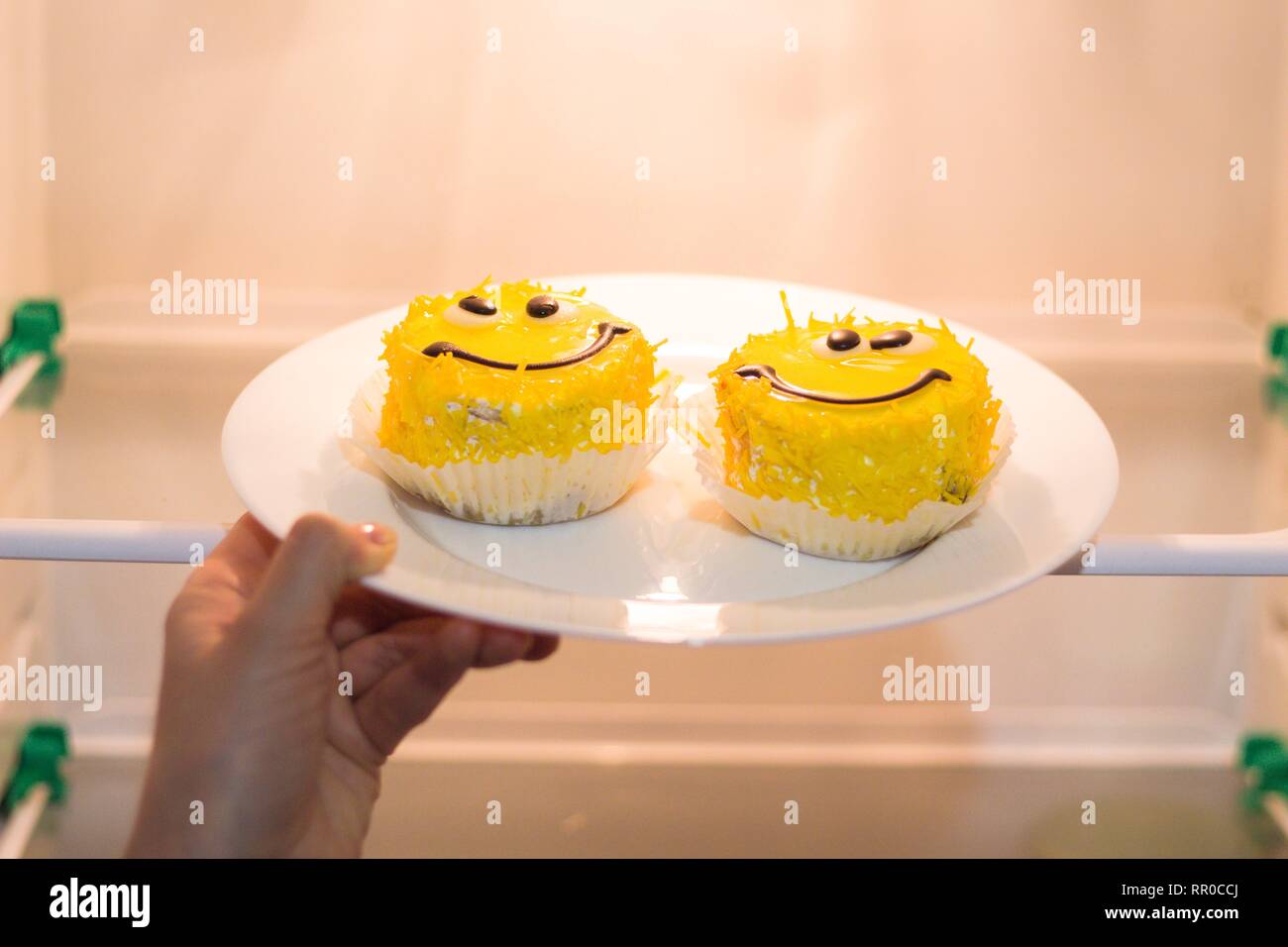 In the refrigerator put two cakes made in the form of faces with eyes