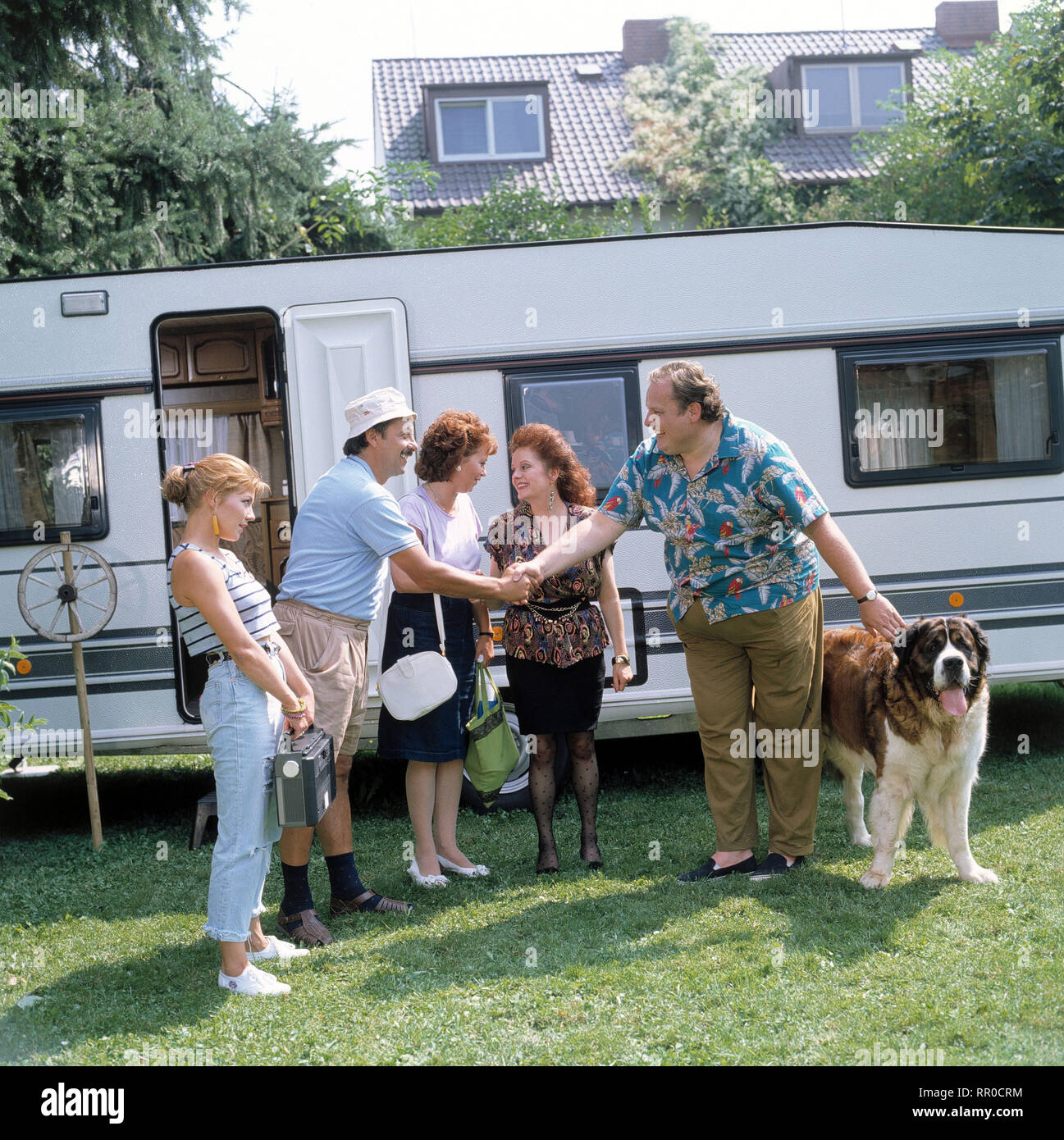 GO TRABI GO / D 1990 - Peter Timm / Ossis treffen Wessis . Familie Struutz beim Verwandtenbesuch in Regensburg. / Udo Struutz (WOLFGANG STUMPH) mit Frau Rita (MARIE GRUBER) und Tochter Jacqueline (CLAUDIA SCHMUTZLER) werden im Wohnwagen von Ritas Schwester Gerda (BILLIE ZÖCKLER) und Ehemann Bernd (OTTFRIED FISCHER) untergebracht. Der fiese Amberger samt Bernhardiner möchte die Gäste bald wieder loswerden. / Überschrift: GO TRABI GO / D 1990 Stock Photo