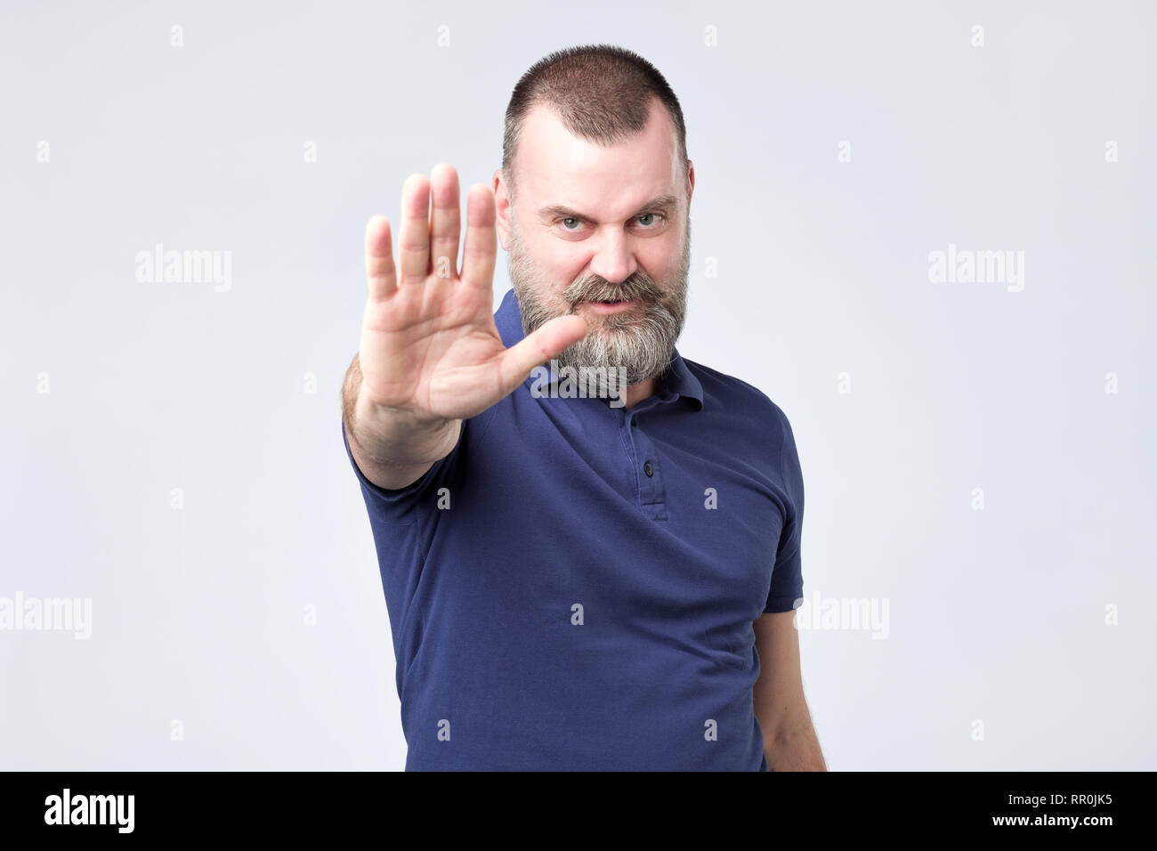 Handsome middle age man annoyed with bad attitude making stop sign with hand, saying no Stock Photo
