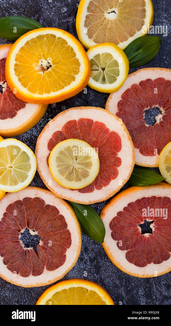 Sliced citrus fruits on black ground Stock Photo Alamy