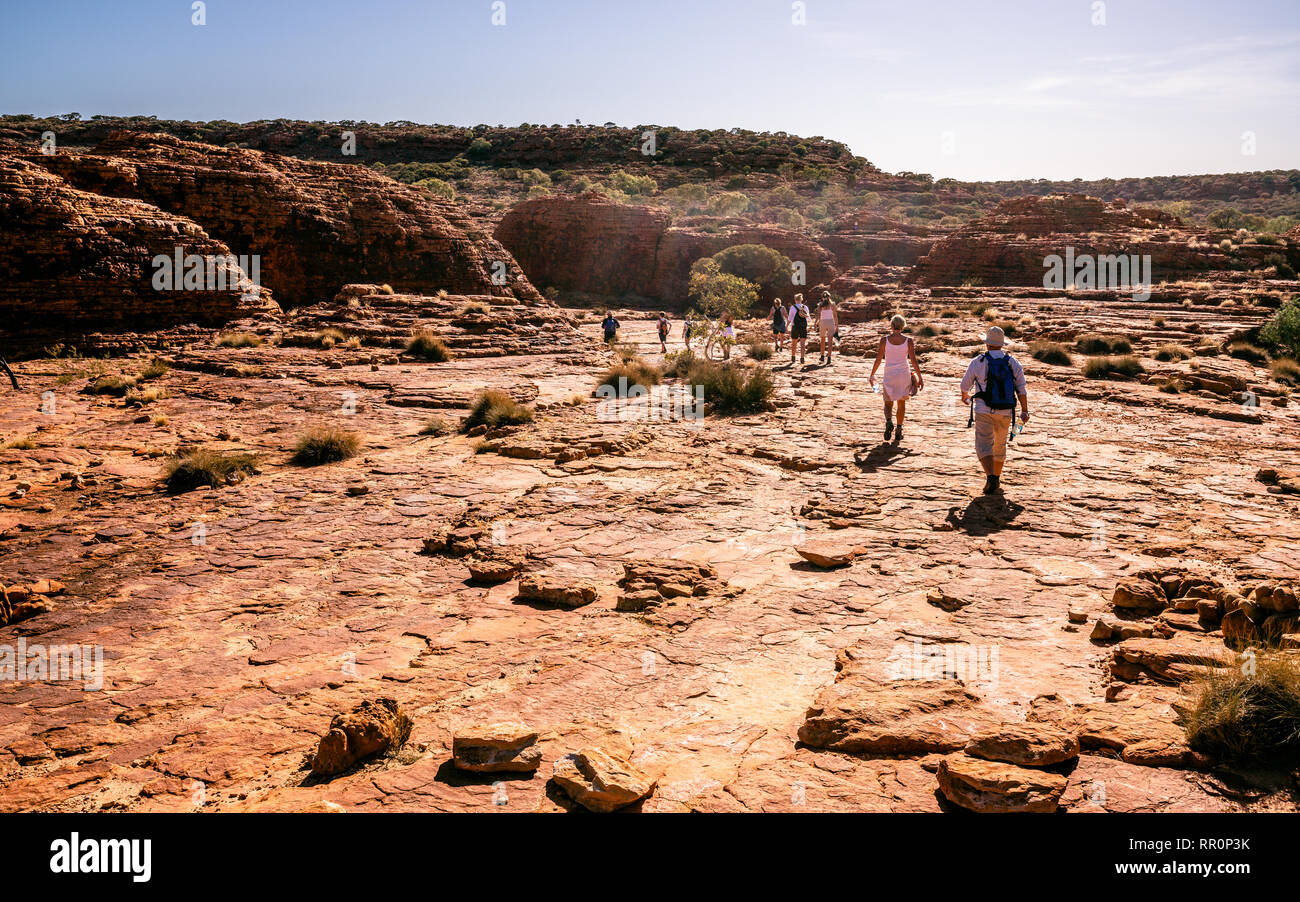 Caucasian people walking under a blazing sun during Rim walking trail at Kings Canyon in NT outback Australia Stock Photo