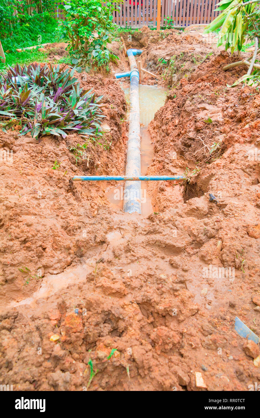 repair plumbing PVC broken pipe in hole which has water with copy space