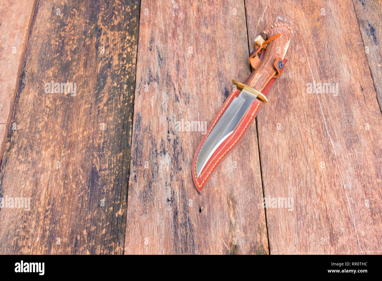 Knife for hiking on sheath brown leather with wooden vintage background