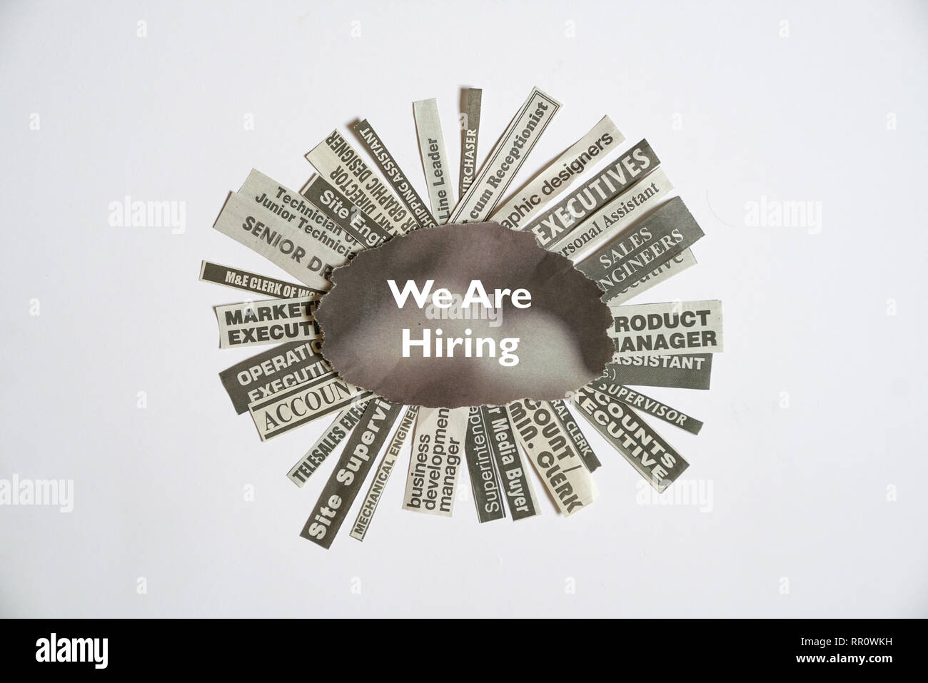 We are hiring. Job titles or vacancies cut off from newspapers on white