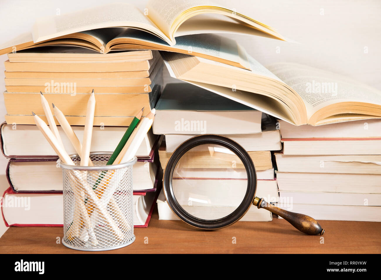 Books and the magnifying glass on wooden background Stock Photo - Alamy