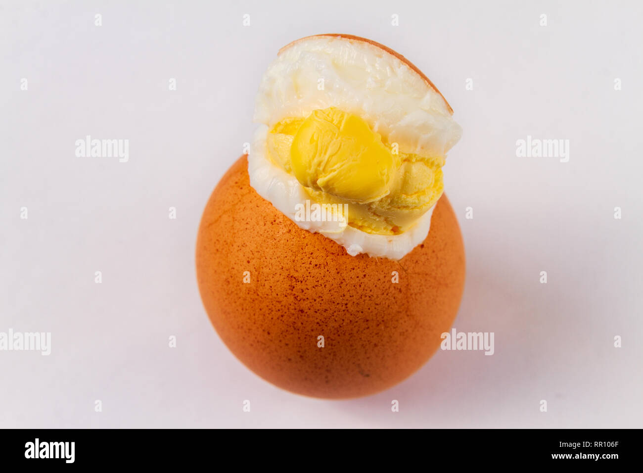 Cracked exploded egg with yoke showing isolated on a white background Stock Photo