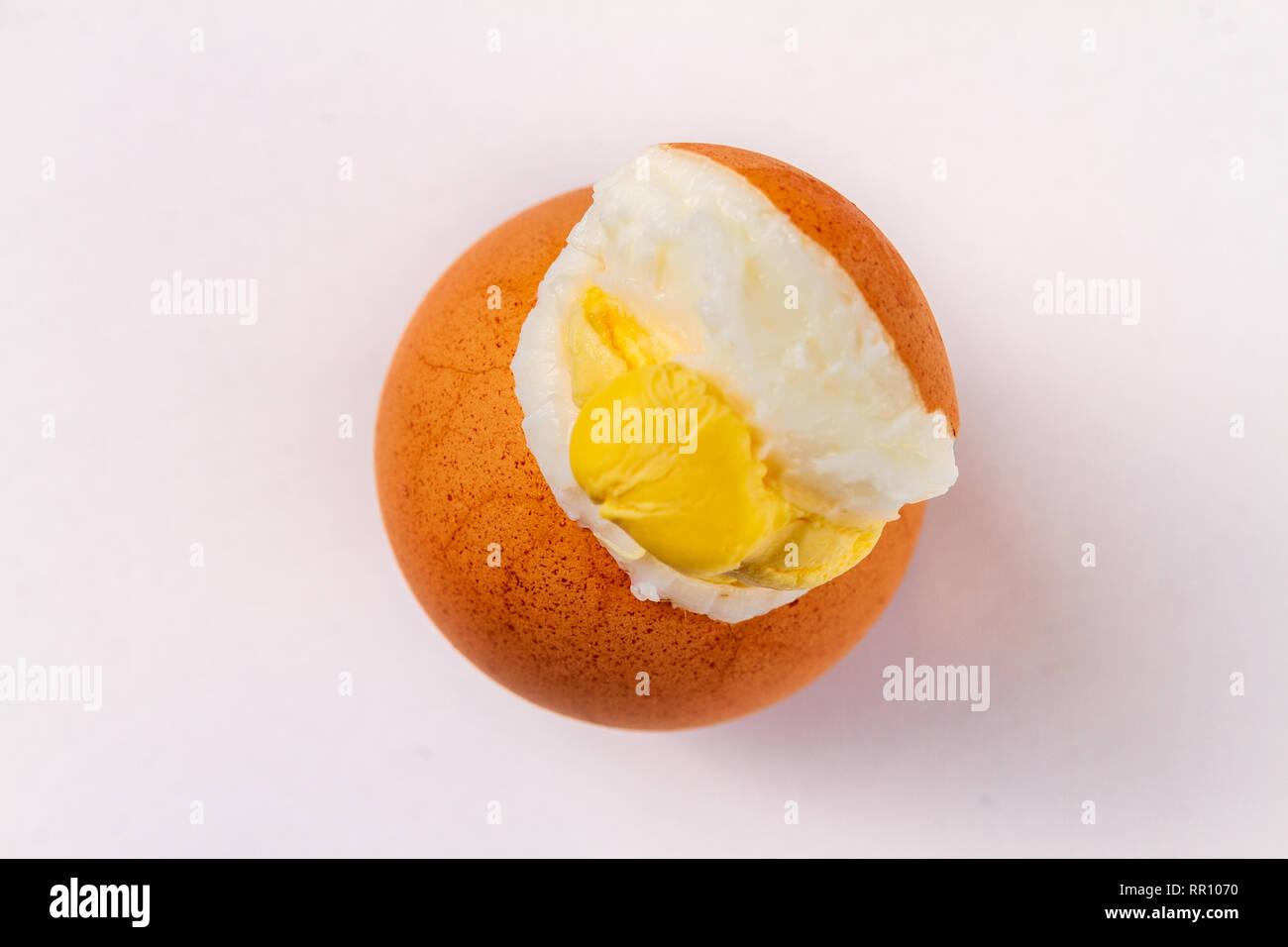 Cracked exploded egg with yoke showing isolated on a white background Stock Photo