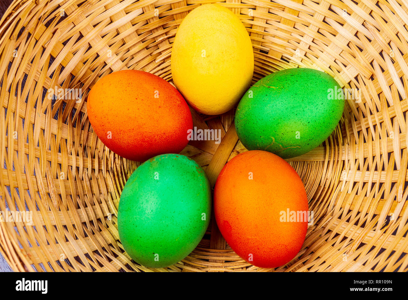 Five colorful easter eggs in a straw basket isolated Stock Photo