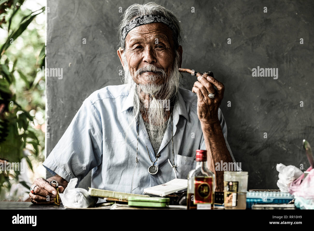 Portrait of an elderly Japanese man smoking a pipe while on the