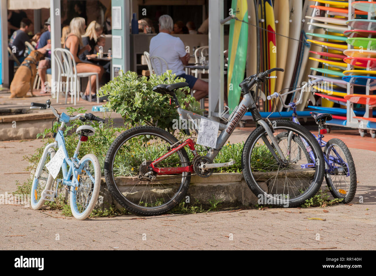 Children's used or second hand bicycles for sale outside a surf shop at the Sydney suburb of South Steyne Stock Photo