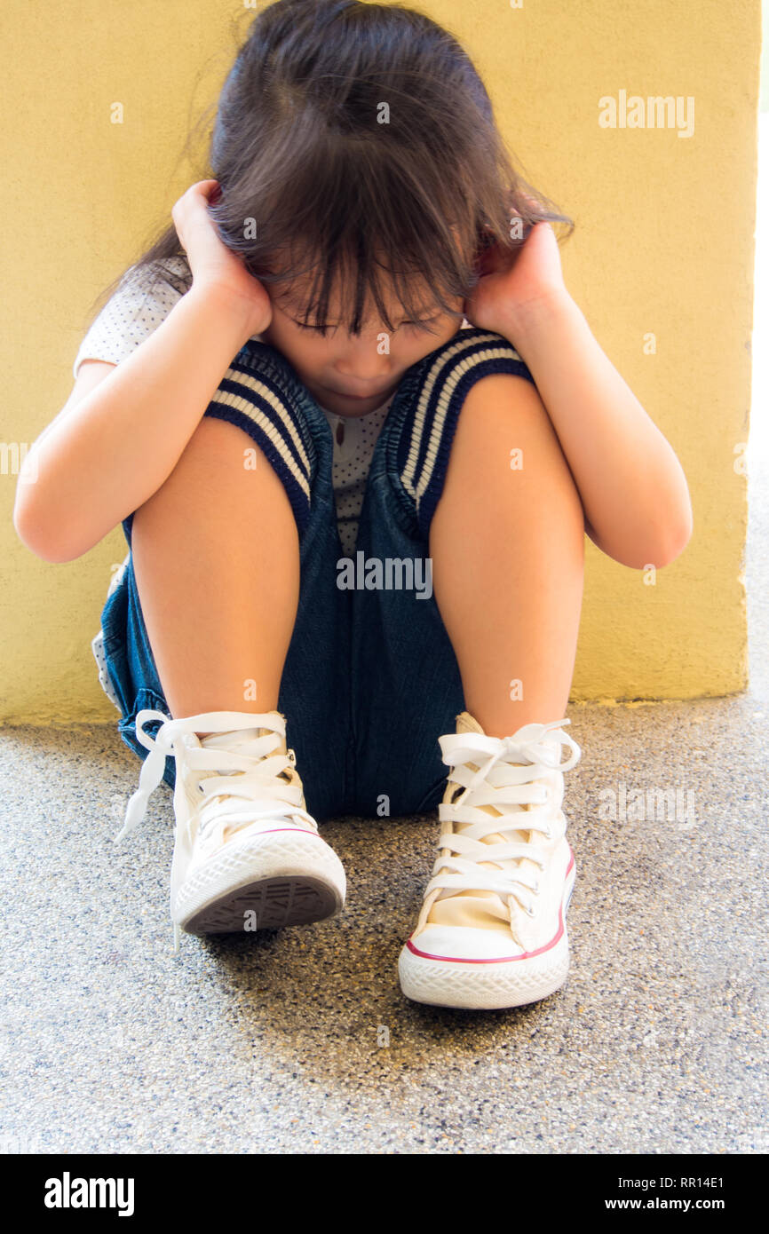 A Lonely girl sitting behind the concrete wall Stock Photo - Alamy