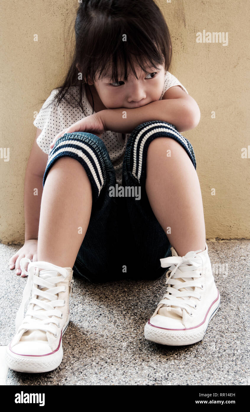 A Lonely girl sitting behind the concrete wall Stock Photo - Alamy