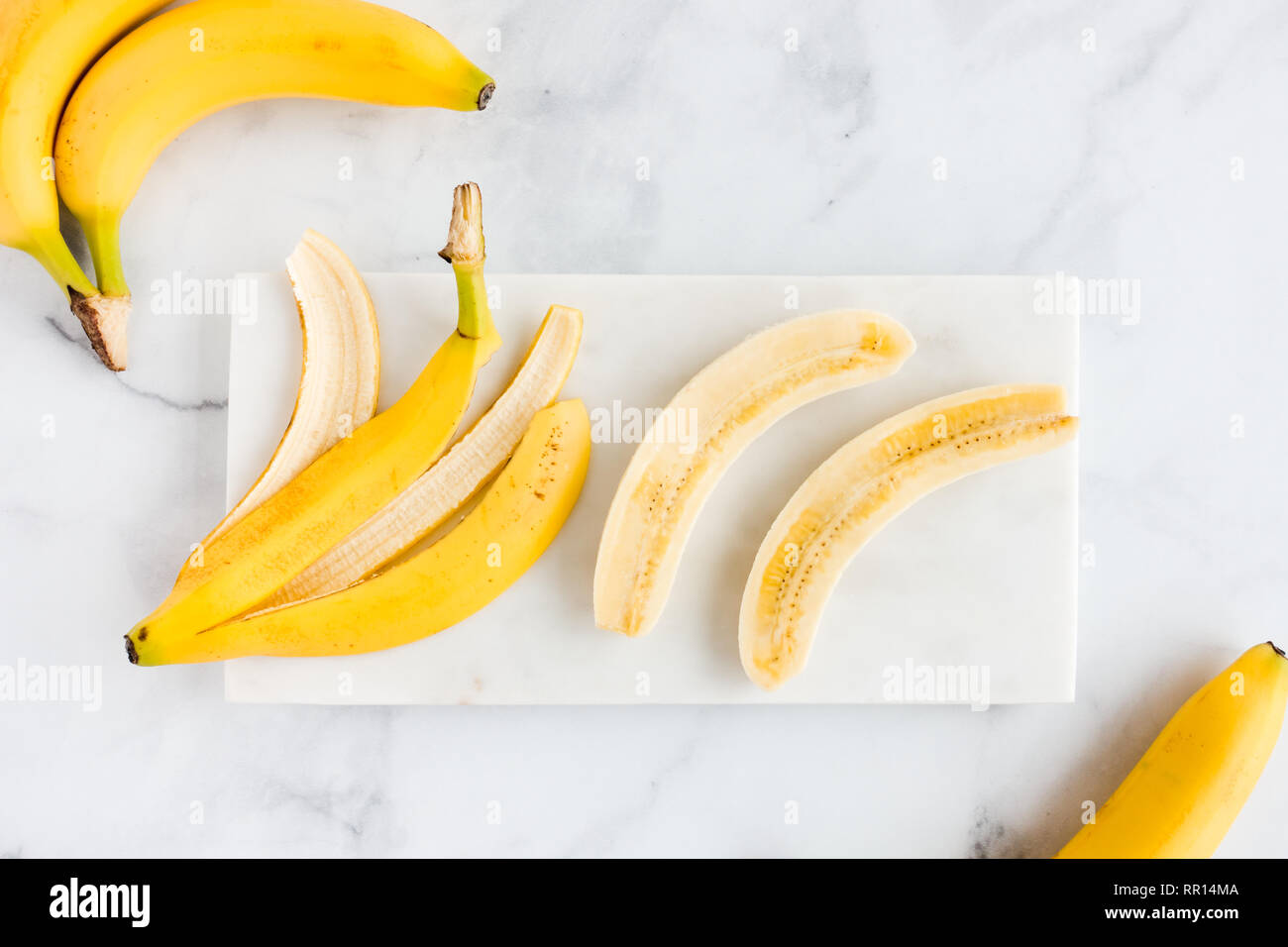 Bananas Banana Peel And A Peeled Banana Cut Lengthwise In Half On White Marble Board And Marble Background Top View Stock Photo Alamy