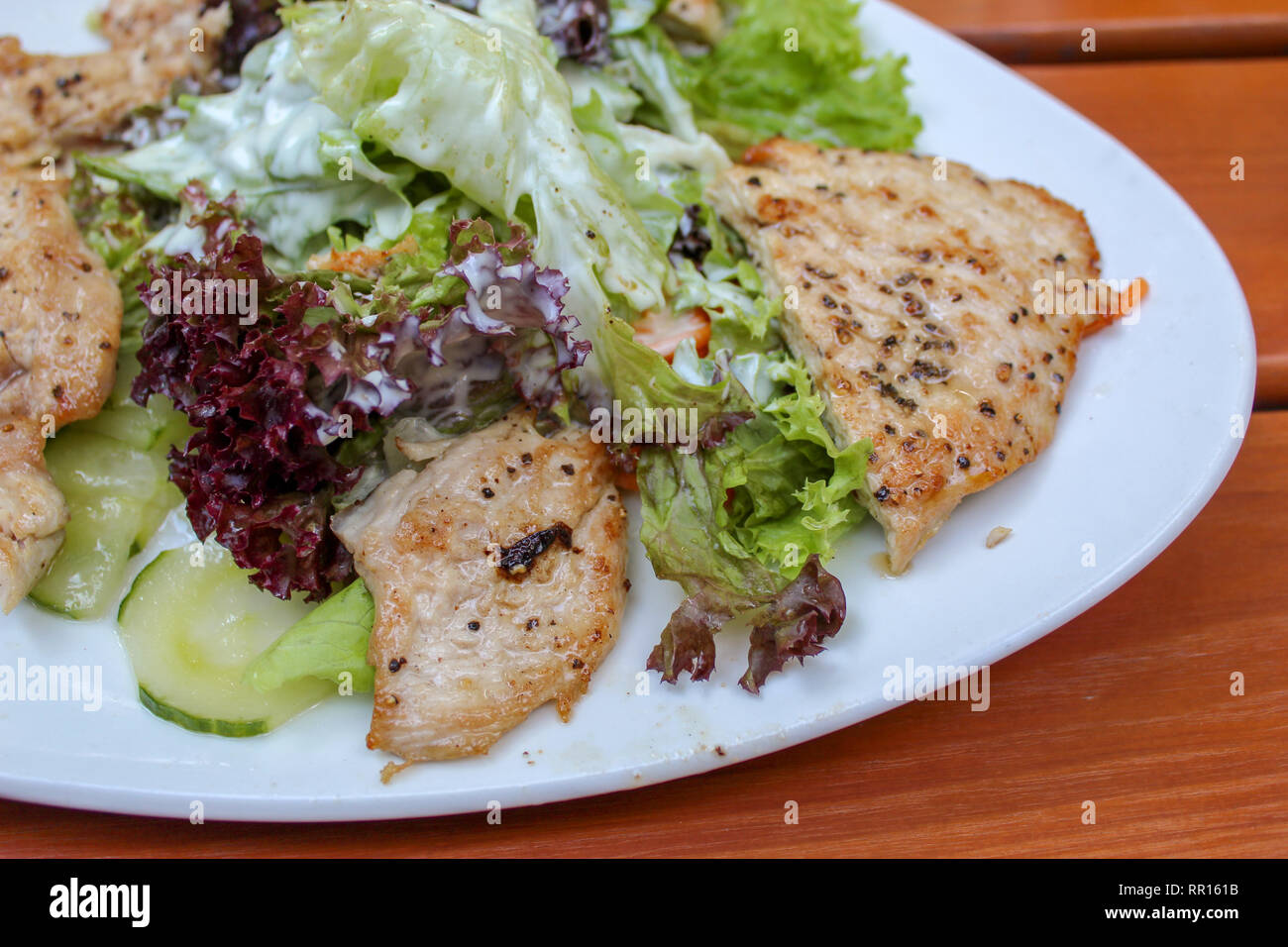 Delicious salad with turkey or chicken stripes and yoghurt dressing closeup Stock Photo