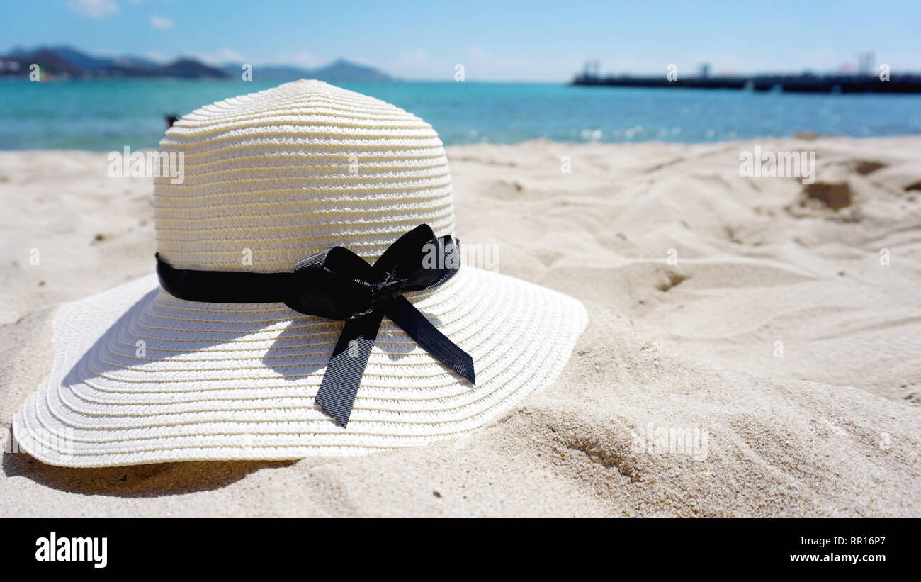 Beautiful Tropical Beach blue ocean background with a hat on the yellow ...
