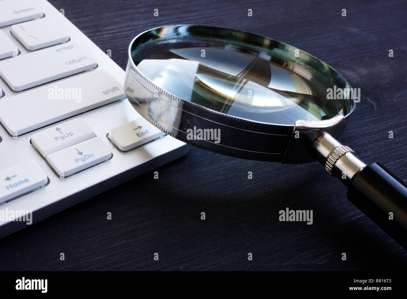 Keyboard and magnifying glass.SEO and IT audit concept. Stock Photo