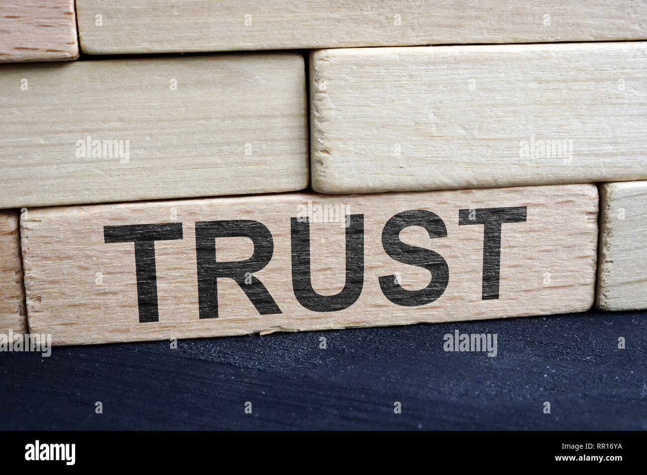 Trust and relationship concept. Wall from wooden bricks. Stock Photo