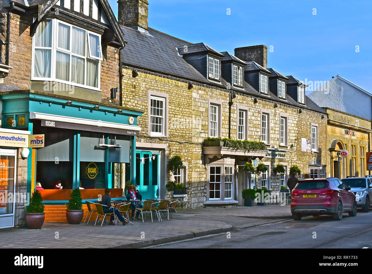 A view of the High Street in Cowbridge with it's  mix of famous brands and small local specialist shops. Showing Oscars coffee shop & The Bear Hotel. Stock Photo
