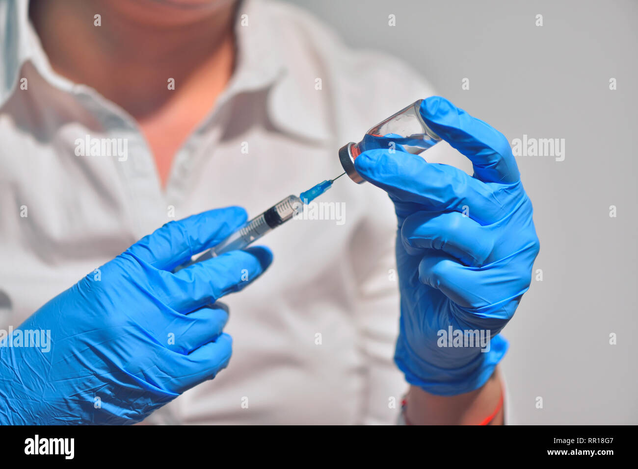 Closeup of vaccine bottle with syringe and needle for immunization on vintage medical background, medicine and drug concept Stock Photo
