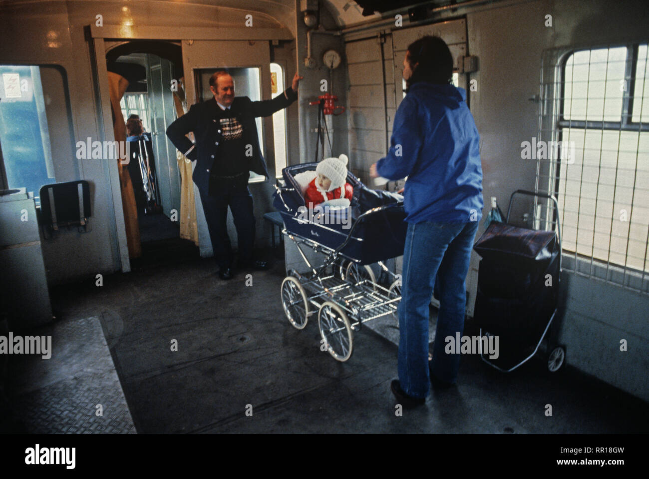 British Rail guard with mother and child in pram in train guards van on