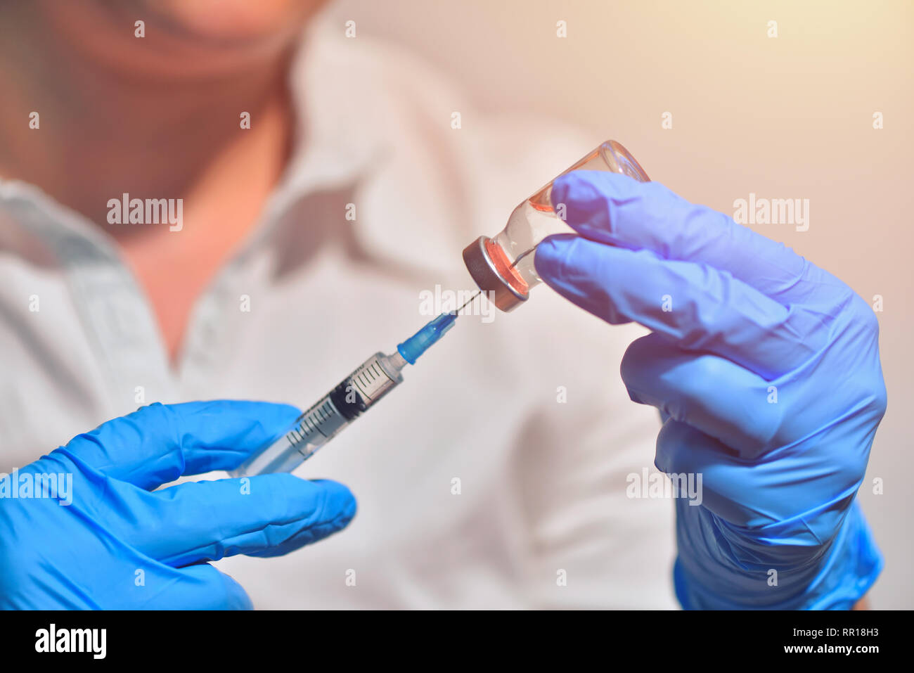 Closeup of vaccine bottle with syringe and needle for immunization on vintage medical background, medicine and drug concept Stock Photo