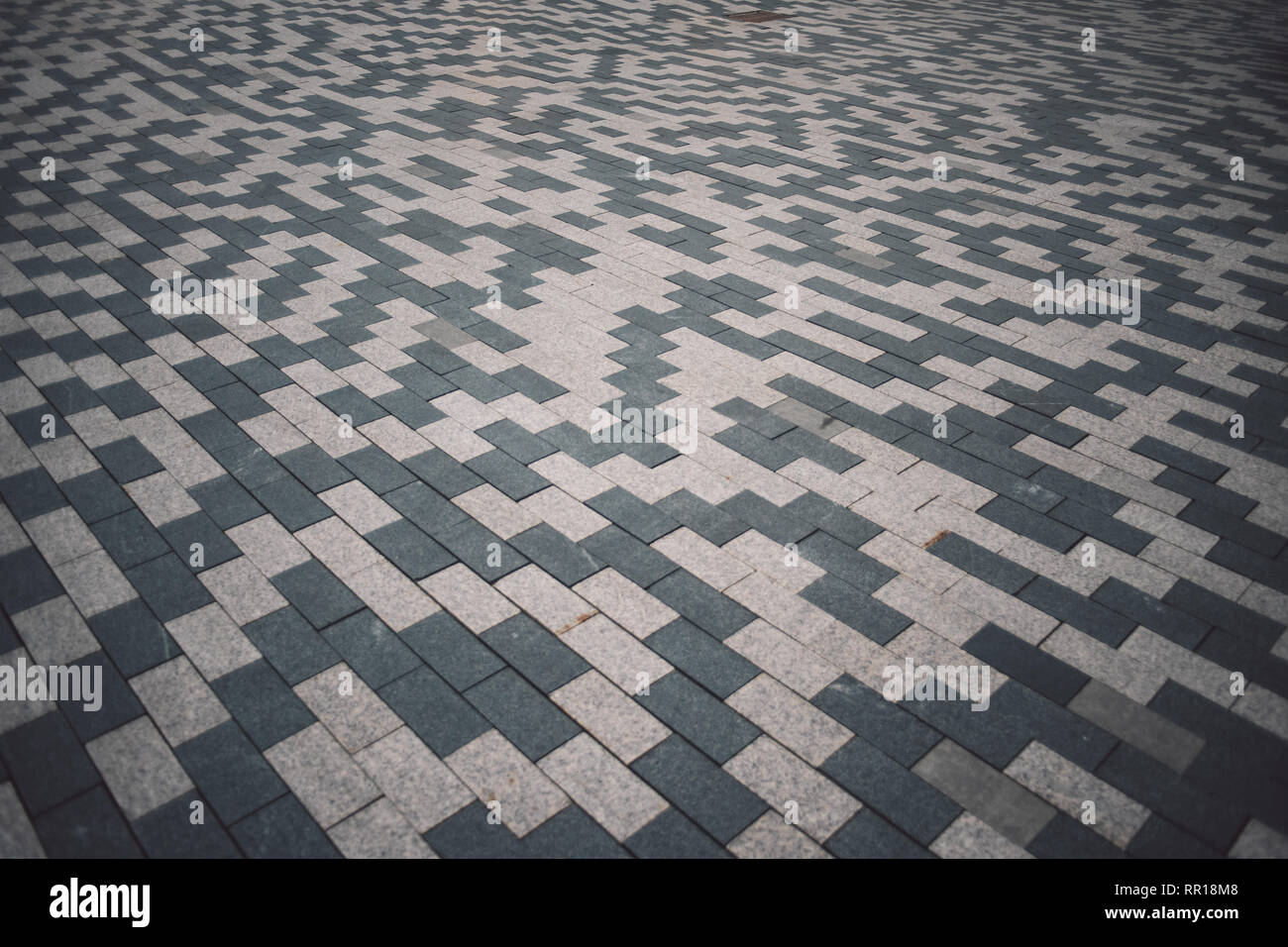 Gray and white patterned paving tiles on the ground of street, perspective view. Cement brick squared stone floor background. Concrete paving slab fla Stock Photo
