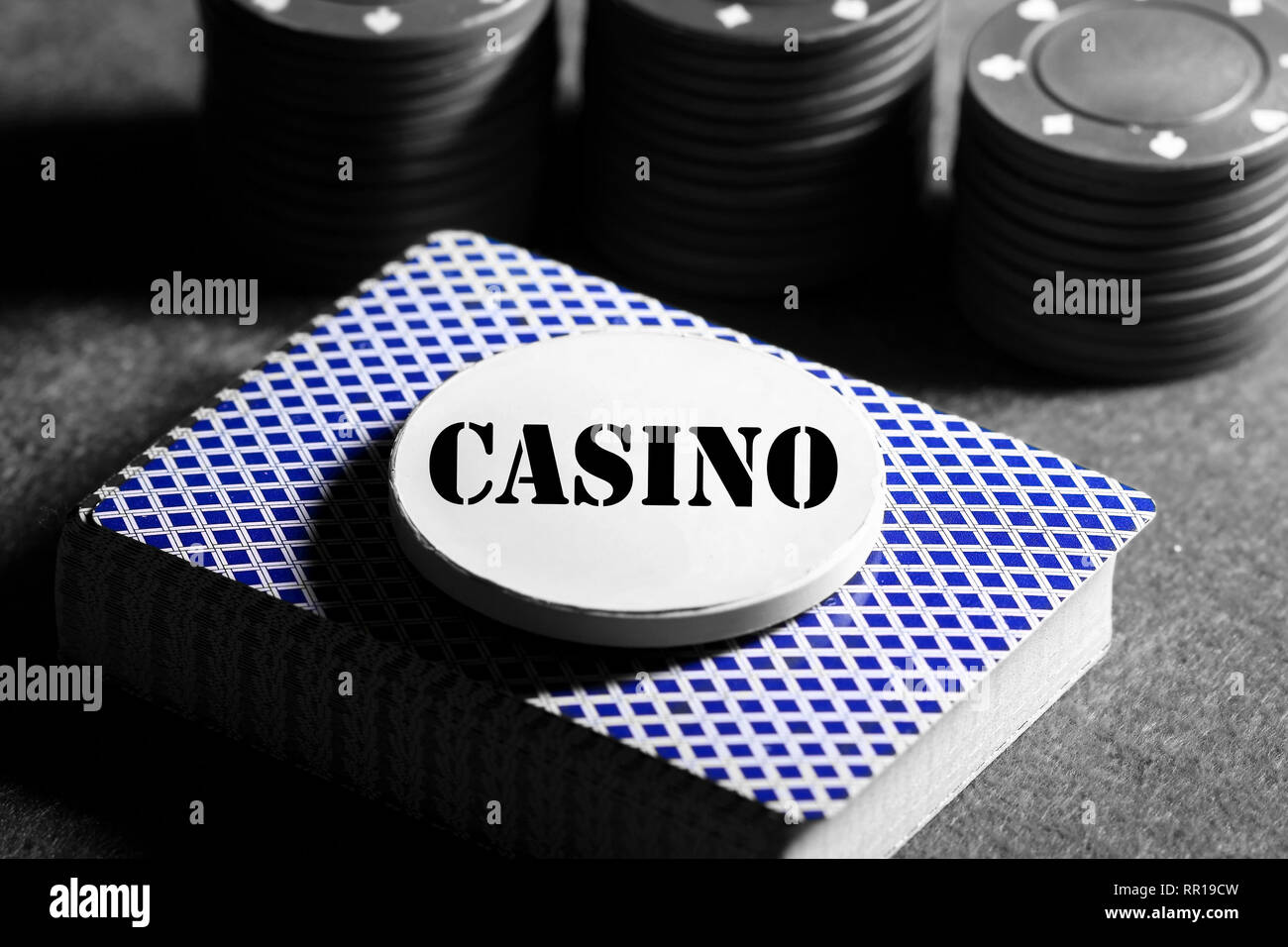 Deck of playing cards with a token on top with the word casino and