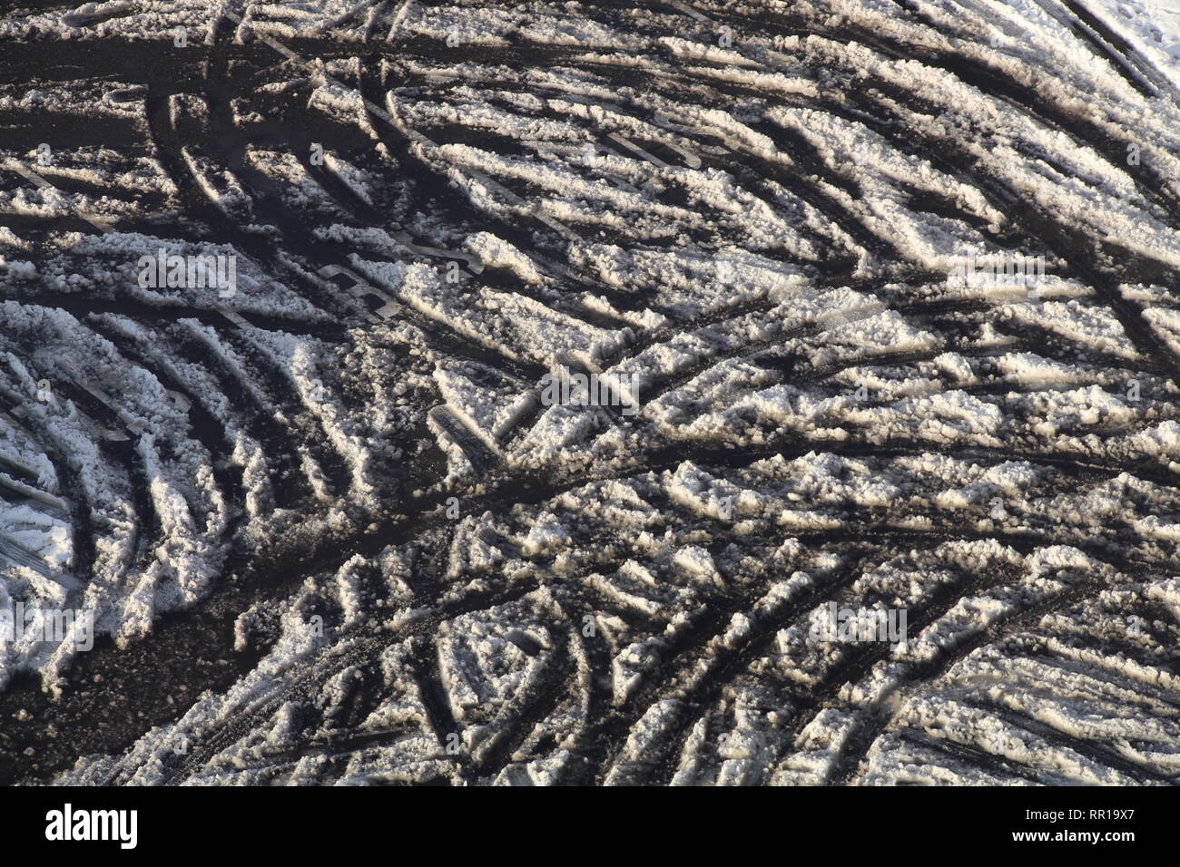 Numerous car tires made tracks upon snow in Prosek, Prague, Czech