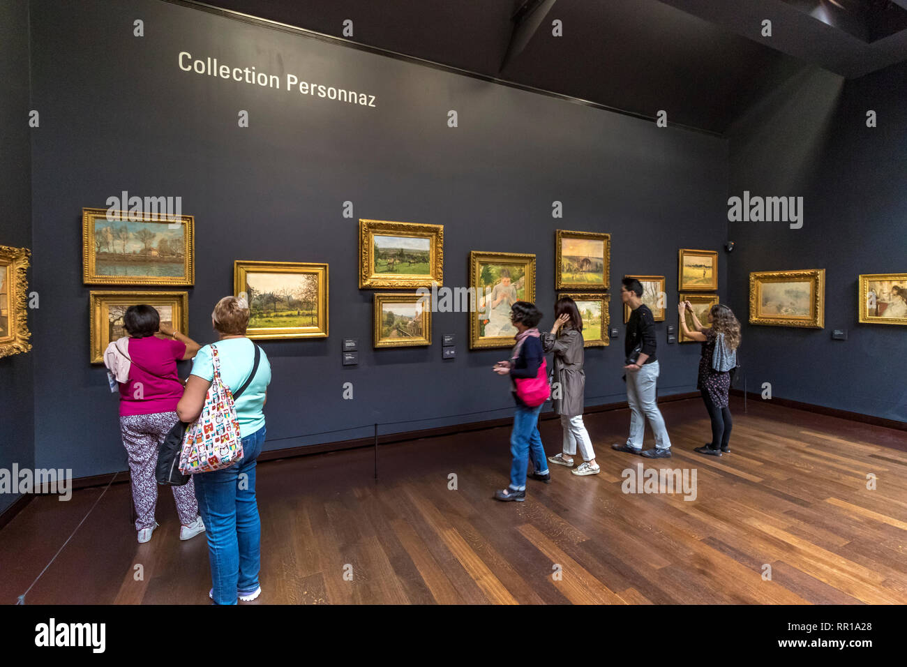 People viewing  impressionist and post-Impressionist masterpieces on the 5th floor of  Musée d'Orsay , a converted railway station in Paris ,France Stock Photo