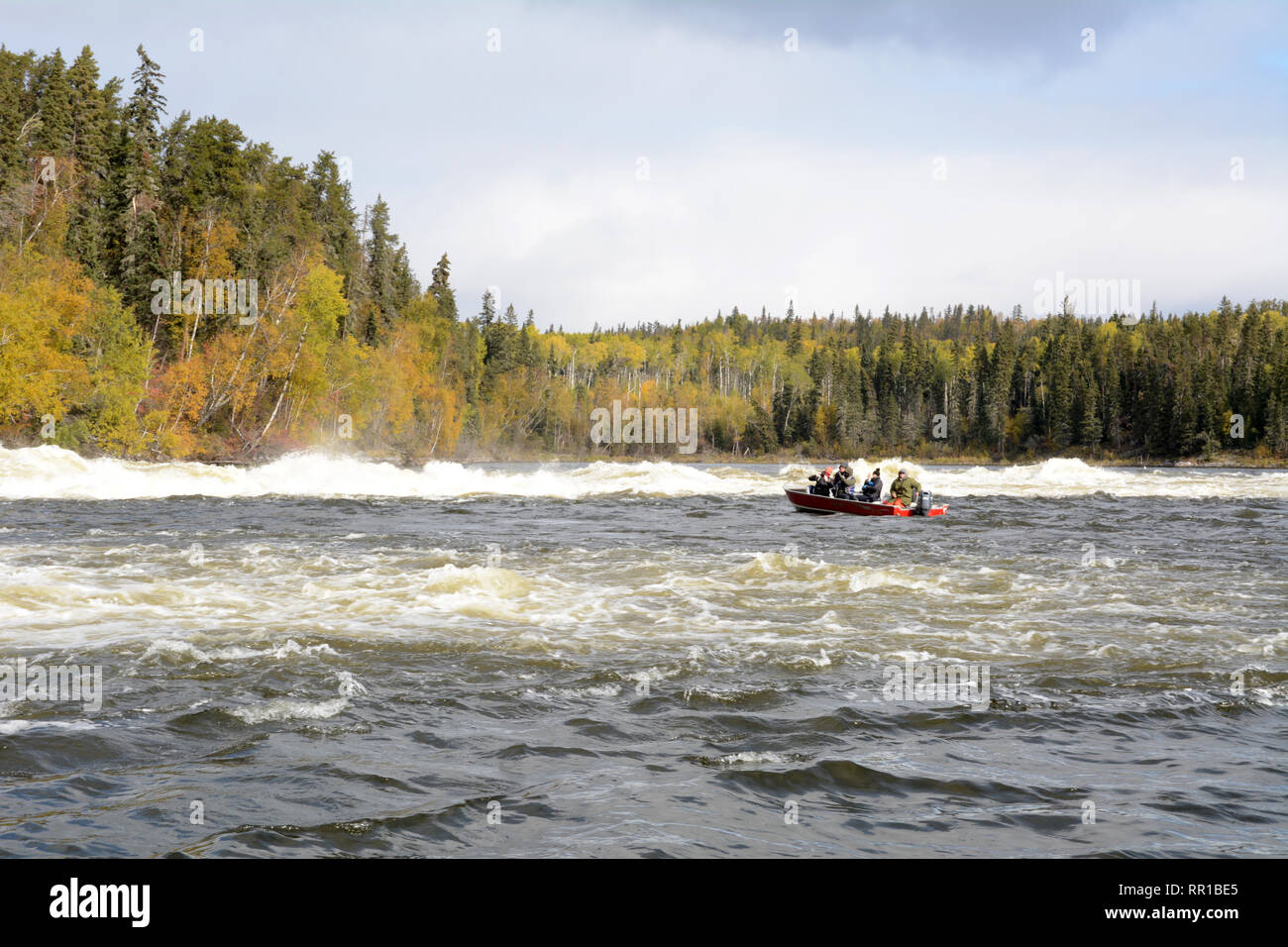 A motorboat carrying tourists at Twin Falls, on the Churchill River, in the boreal forest of northern Saskatchewan, near Stanley Mission, Canada. Stock Photo