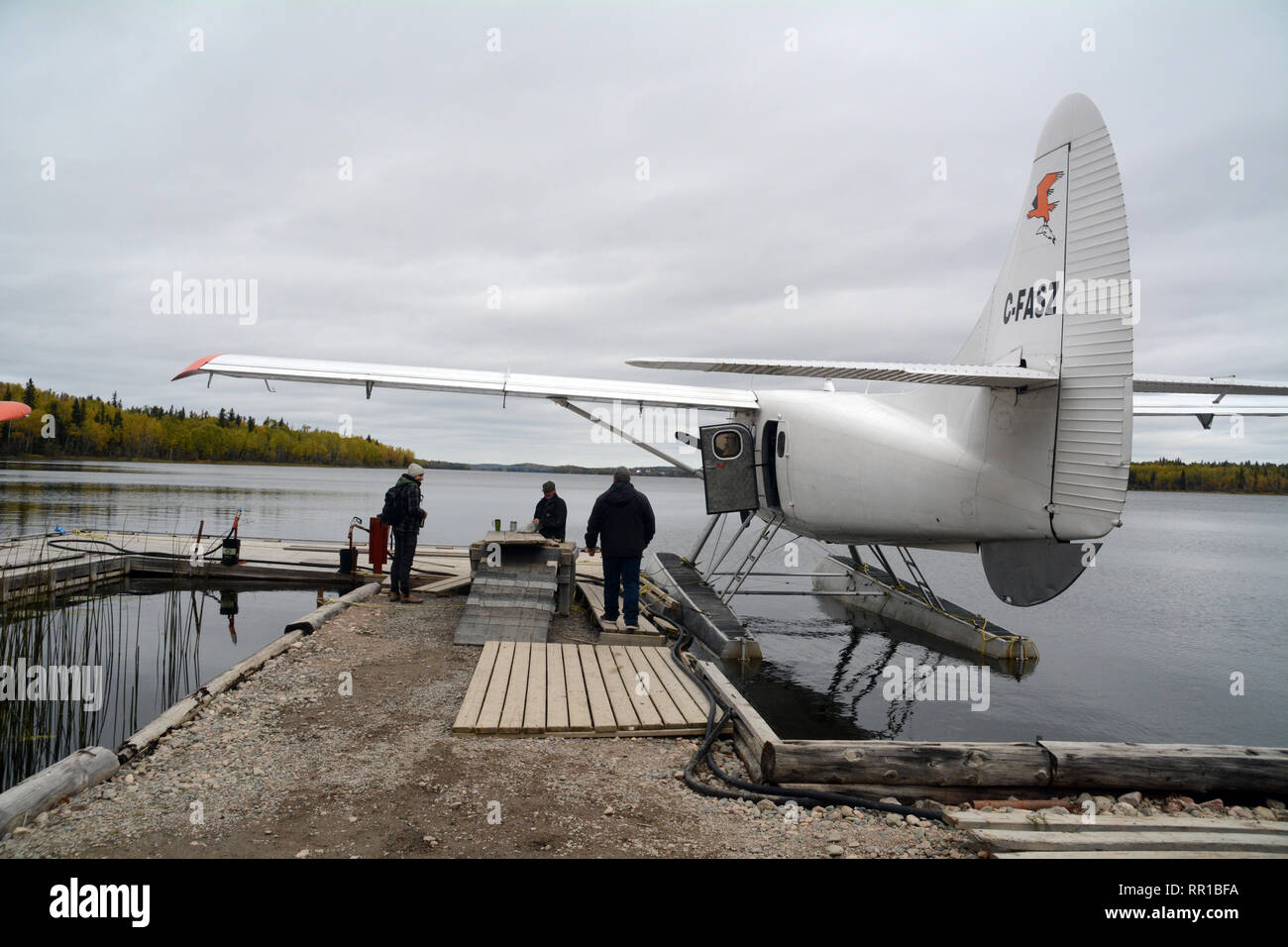 A float plane pilot preparing for flight on a dock at a lake near the town of Stanley Mission, in northern Saskatchewan, Canada. Stock Photo
