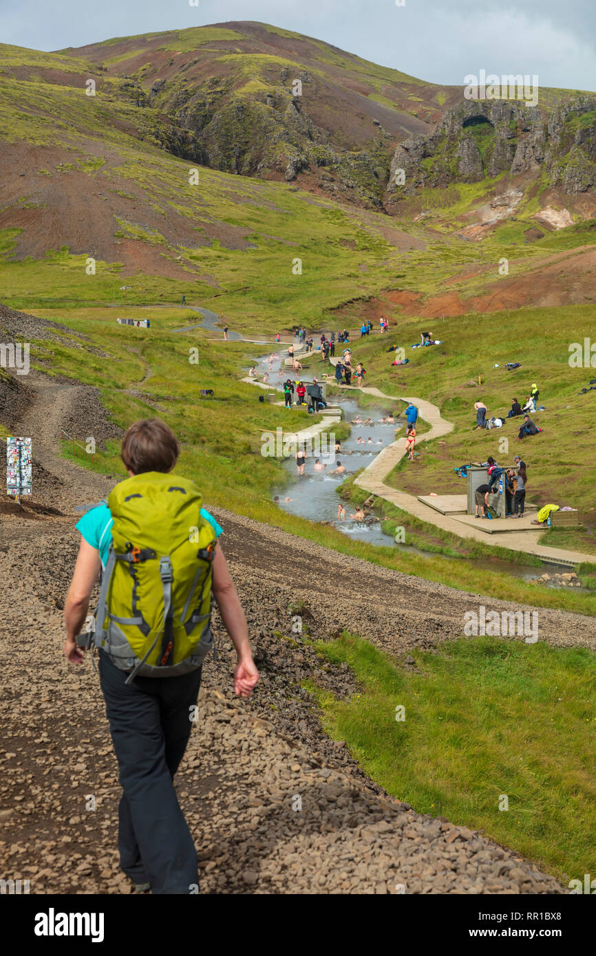 Hiker approaching the hot spring bathing river in the Reykjadalur valley. Hveragerdi, south Iceland. Stock Photo