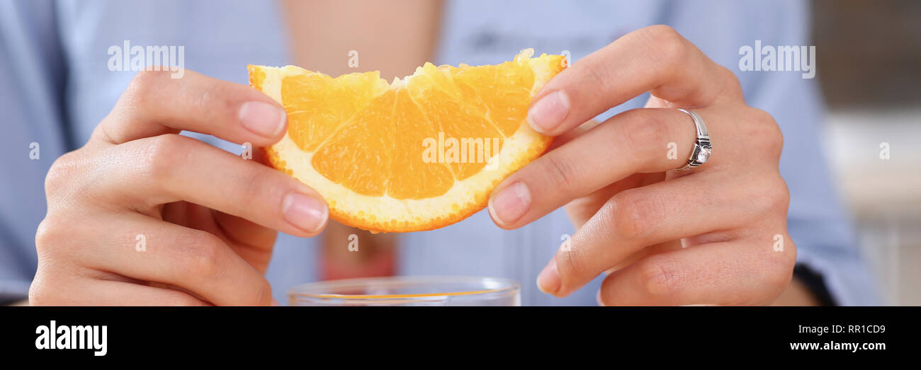 Female arms hold slides orange and glass of juice Stock Photo